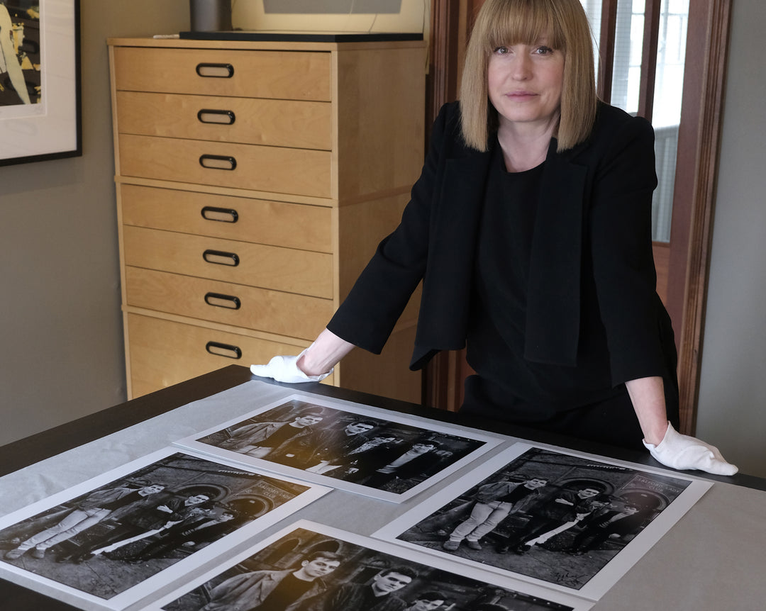 The Smiths album cover  prints laid out on table at Hypergallery's print room, with gallery owner Emily in shot